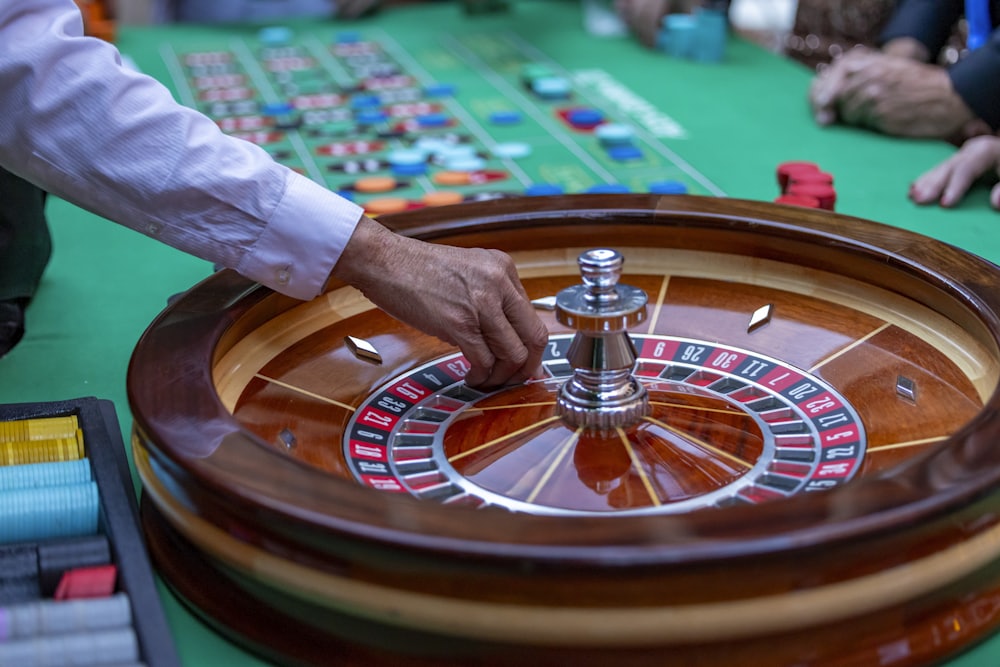Pemain memasang taruhan roulette di meja hijau