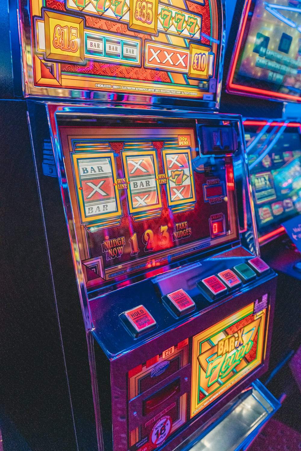 Mesin slot menyala dengan efek cahaya di ruangan gelap