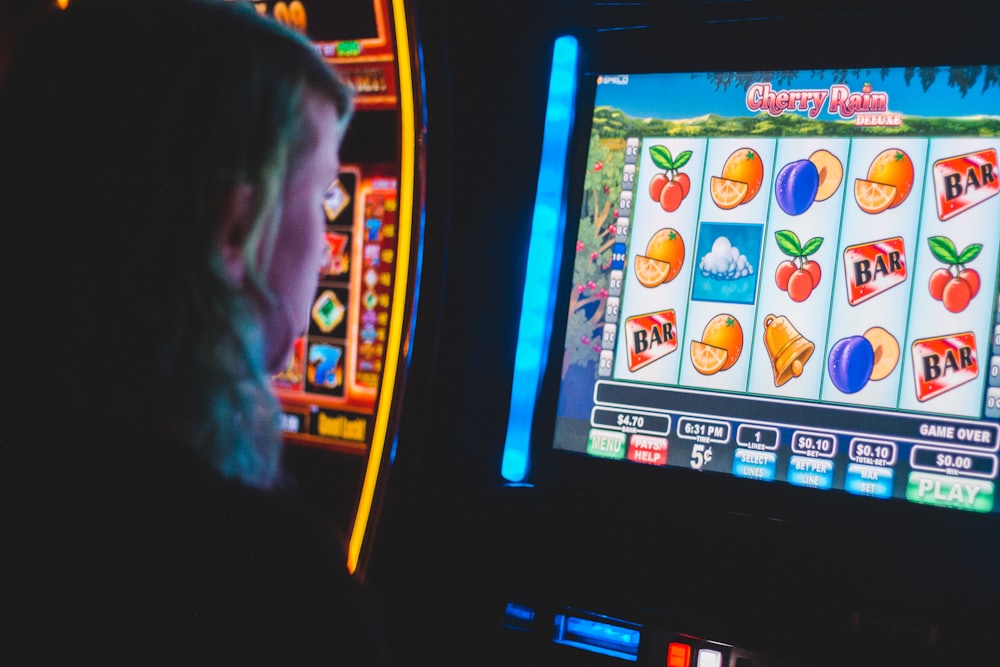 Pria menekan tombol putar pada mesin slot